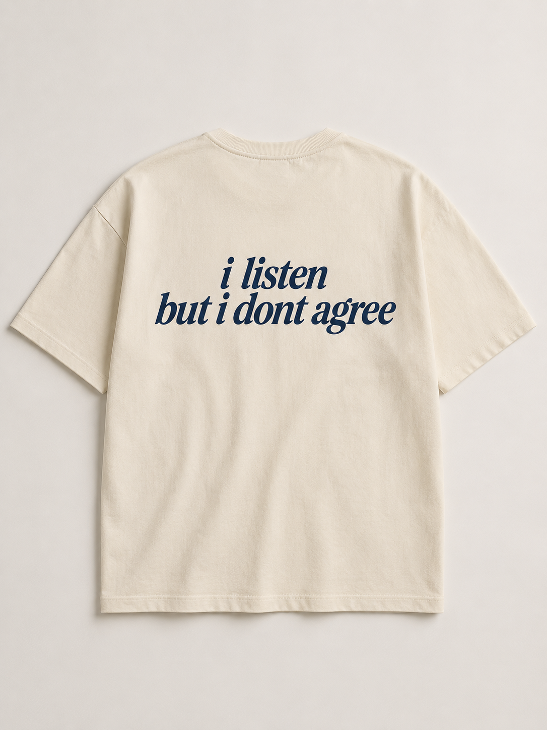 Back of cream SORRY BABY shirt reading i listen but i dont agree in lowercase serif italic