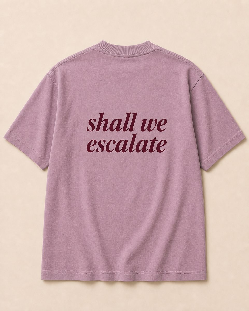 Back of baby pink SORRY BABY shirt reading shall we escalate in lowercase serif italic