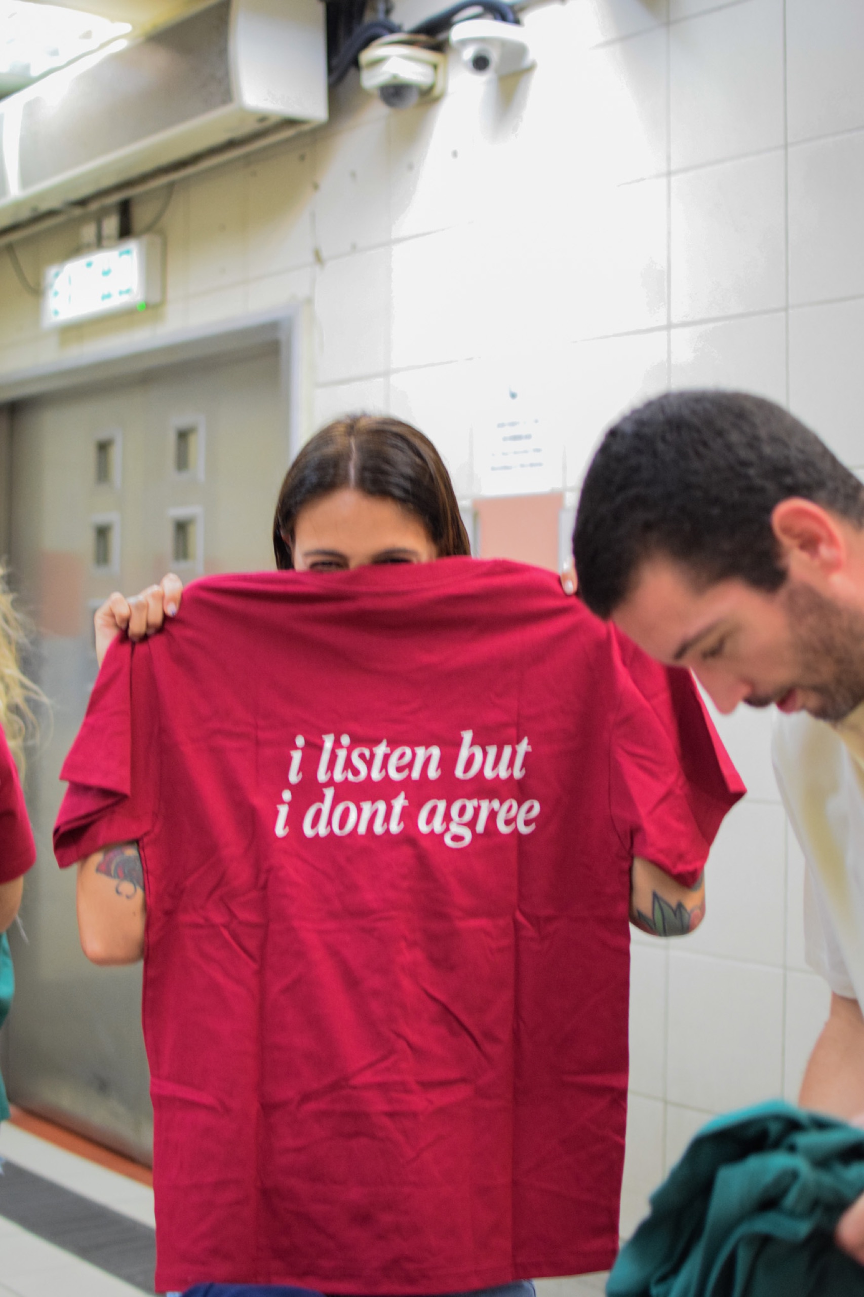 Burgundy SORRY BABY shirt held up to reveal the phrase i listen but i dont agree